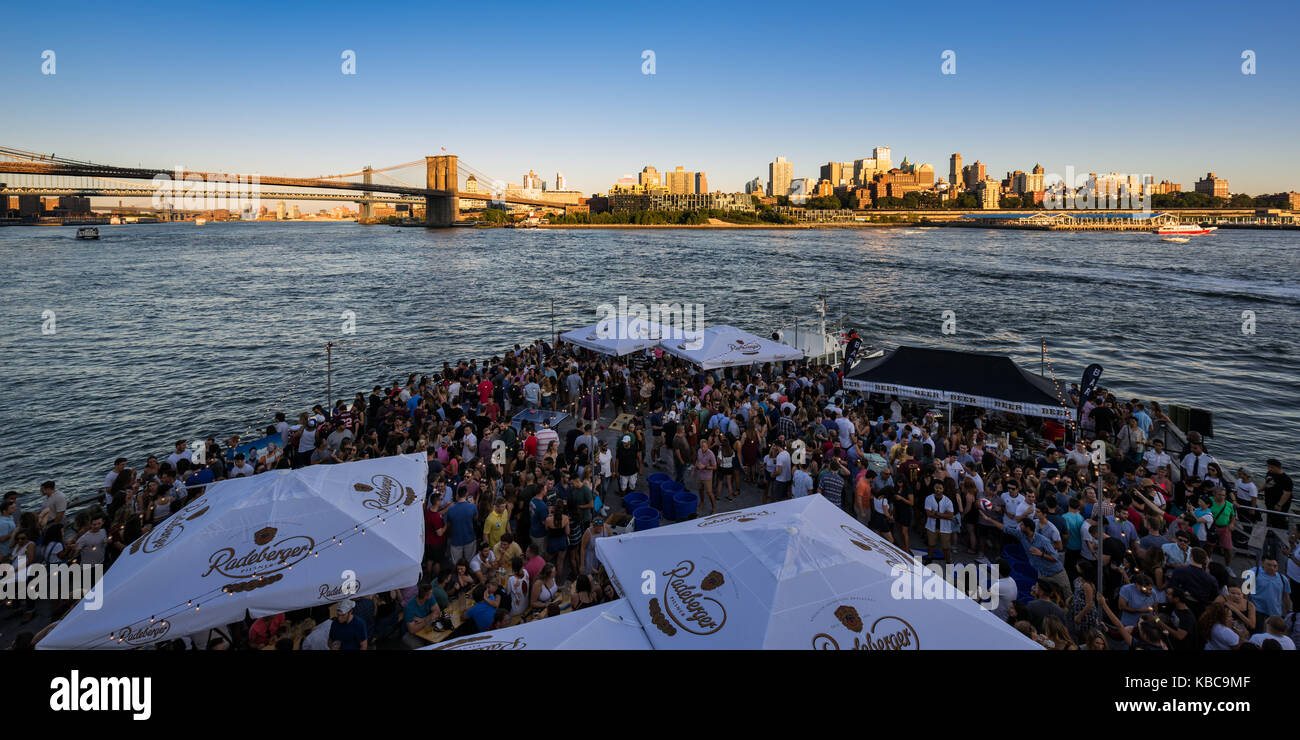 Fête d'été au coucher du soleil sur Pier 15 dans la partie basse de Manhattan avec vue sur Brooklyn Waterfront. New York City Banque D'Images
