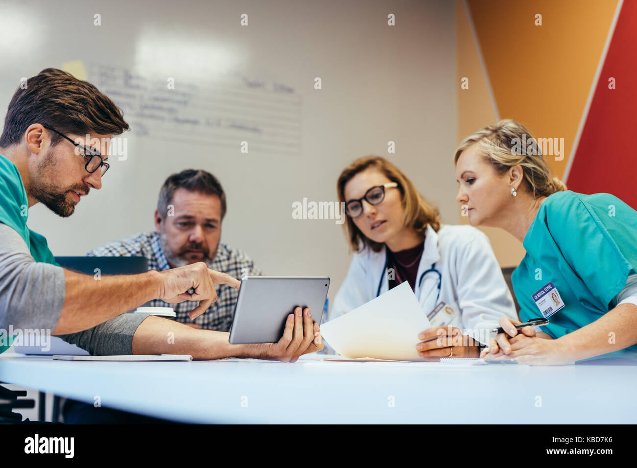 Équipe de travailleurs de la santé ayant une réunion en salle du Conseil. Réunion d'information professionnelle médicale Plan de médicaments à des collègues sur tablette numérique. Banque D'Images