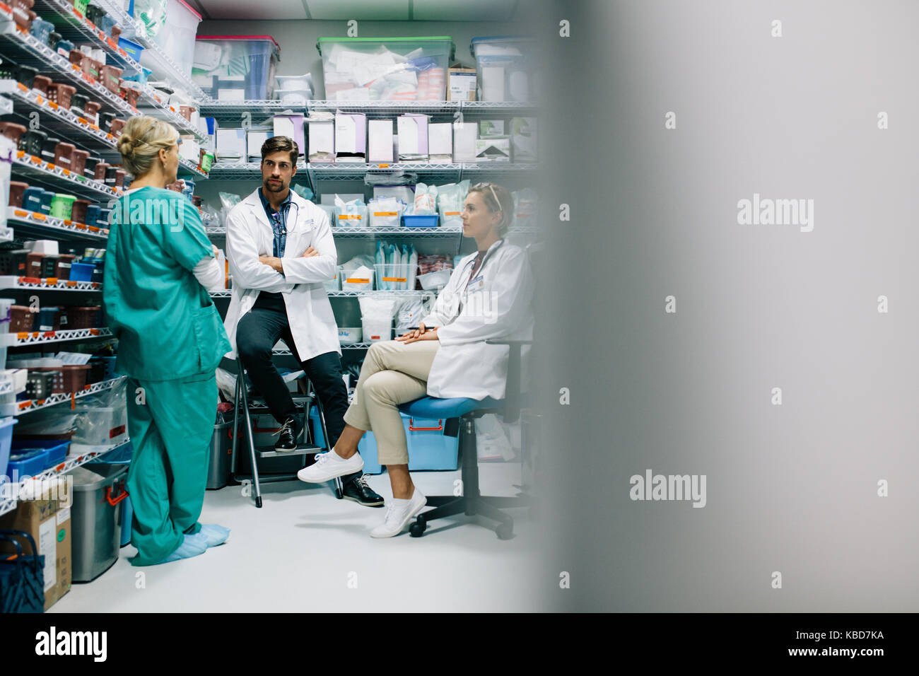 Le personnel de l'hôpital de discuter ces médicaments dans la pharmacie. Trois collègues réunion en pharmacie et de parler. Banque D'Images