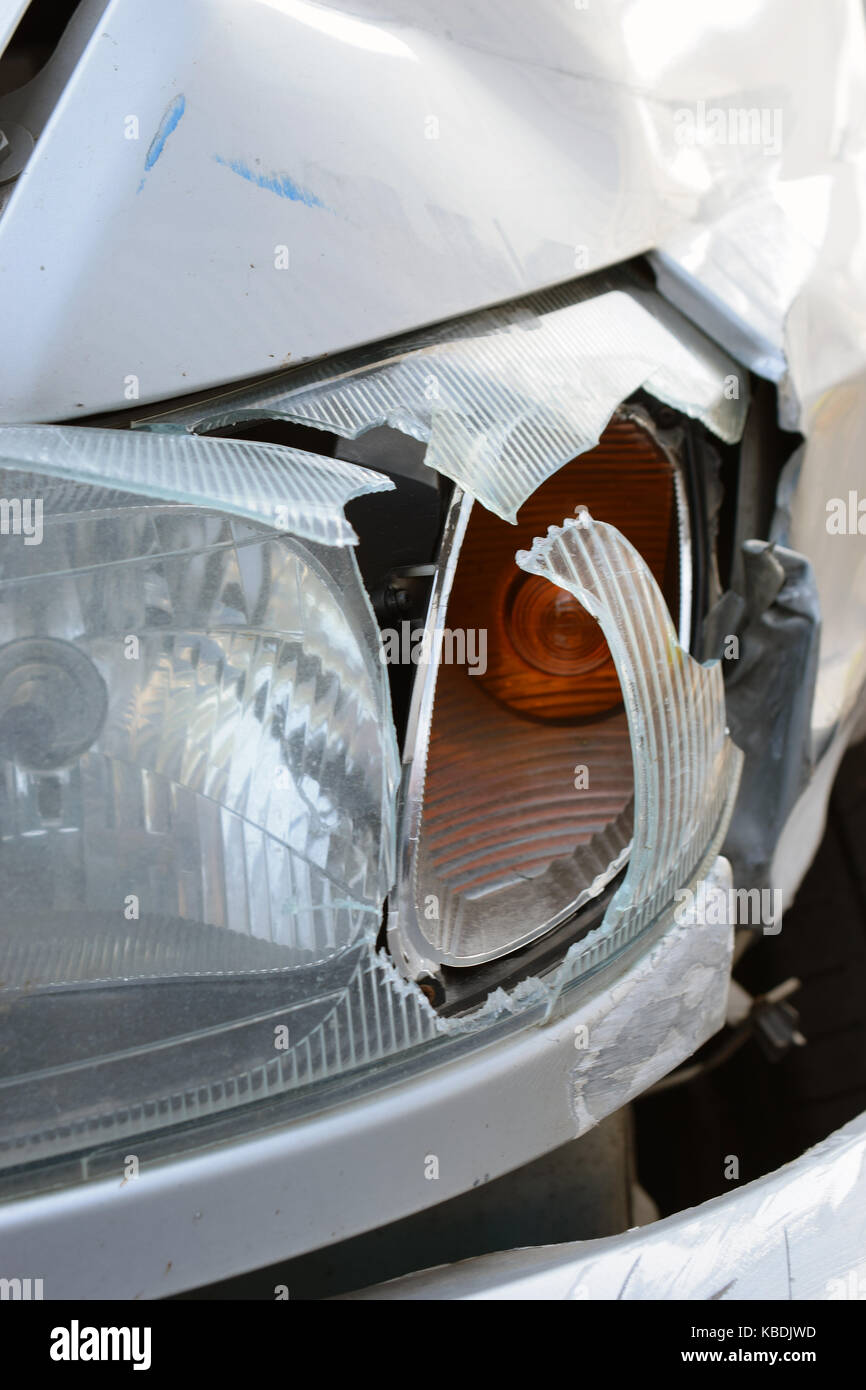 Close up de phare de voiture endommagée après accident. vertical image. Banque D'Images
