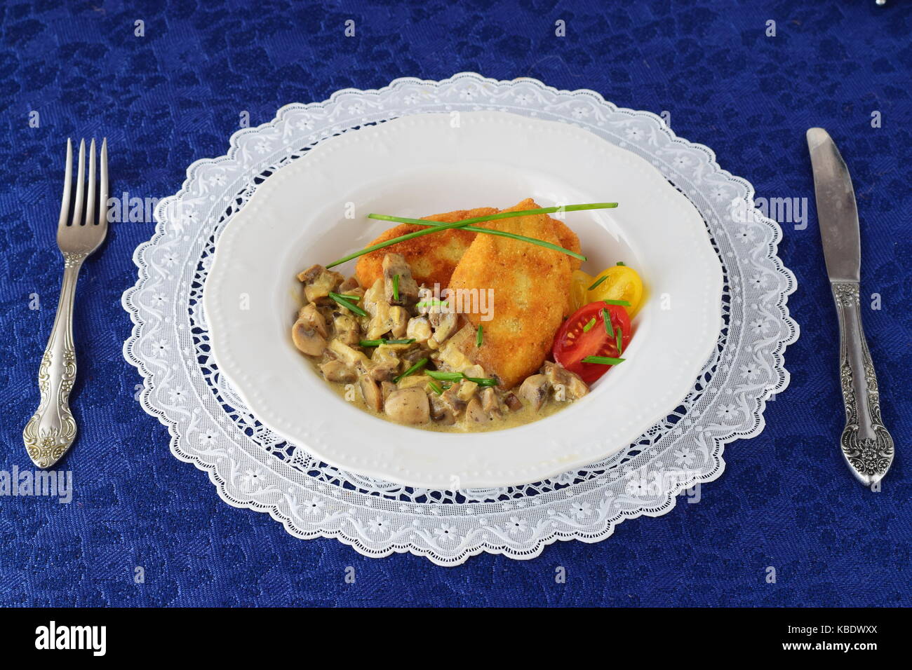 Galettes de pommes de terre avec sauce crémeuse aux champignons dans une assiette blanche sur un tissu bleu. concept d'aliments sains Banque D'Images