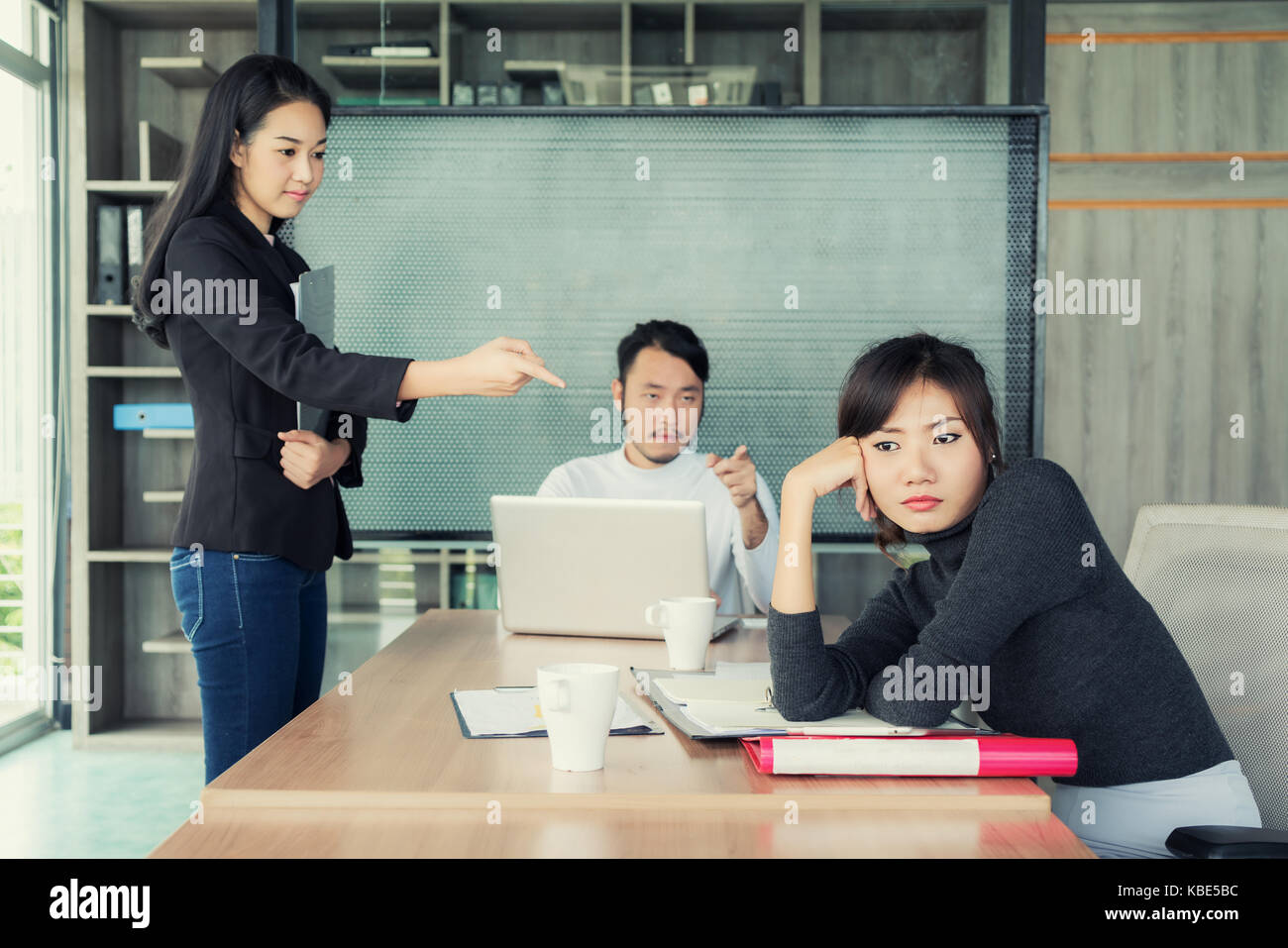 Groupe d'affaires asiatiques à la femme d'en blâmer et collègue de l'échec, mauvais résultats de travail en salle de réunion d'affaires. Banque D'Images