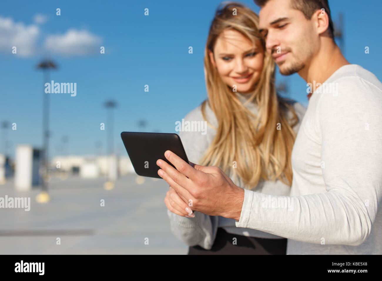Young casual couple browsing internet en plein air comprimé, profondeur de champ Banque D'Images