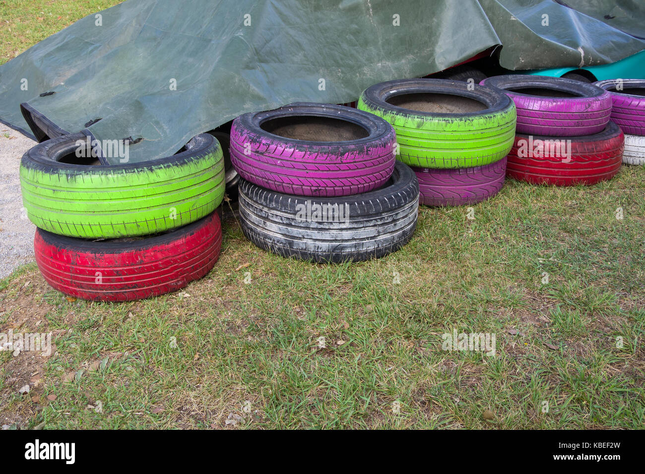 Les vieux pneus de couleur abritées dans pile : peint en vert, violet, blanc Banque D'Images