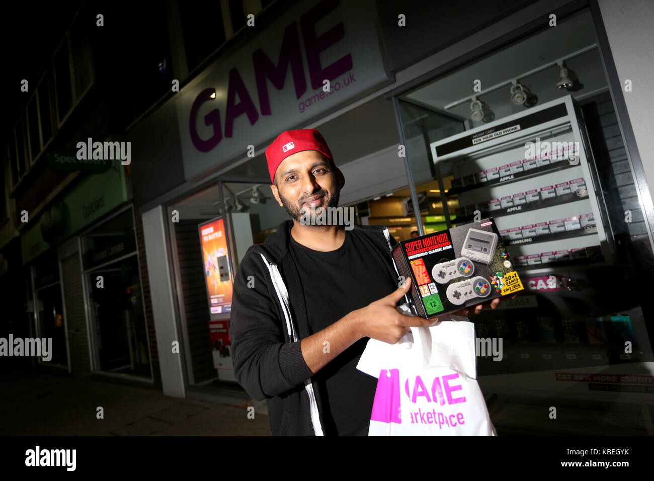 Un homme photographié avec sa nouvelle console de jeux SNES mini d'attente et qu'il a acheté à minuit le jour de la diffusion dans le magasin de jeux à Bognor Regis. Banque D'Images