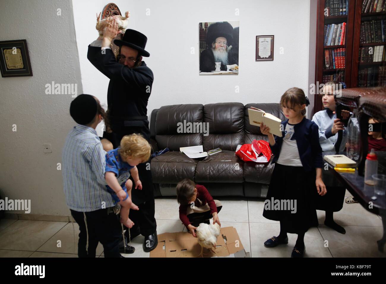 (170929) -- rechovot, sept. 29, 2017 (Xinhua) -- une famille juive ultra-orthodoxe effectuer le traditionnel 'kaparot" cérémonie à leur télévision à rechovot, Israël, sur sept. 28, 2017. Il est de coutume d'effectuer le "cérémonie des kaparot en préparation de Yom Kippour, le jour du grand pardon juif et le jour le plus saint du calendrier juif. (Xinhua / gil cohen magen) (ZW) Banque D'Images