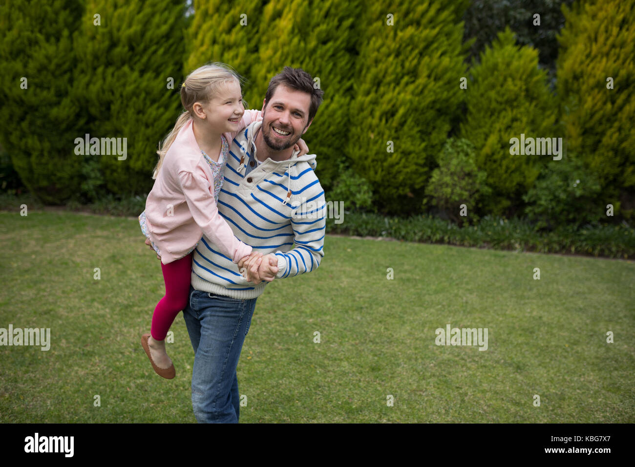 Jeune fille danse avec son père épaules dans le parc Banque D'Images