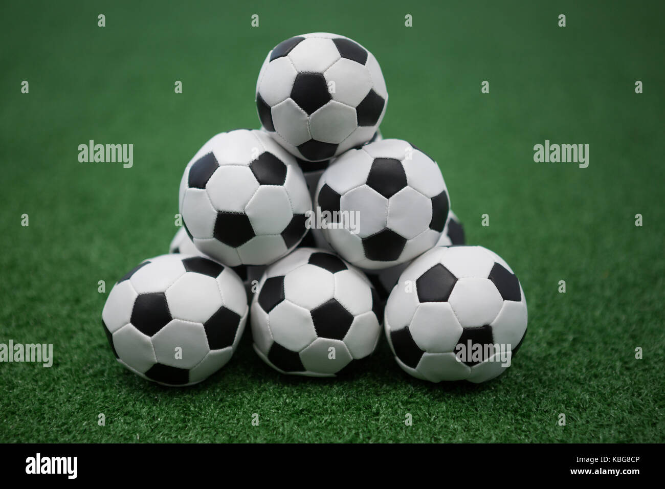 Pile d'empiler les ballons de football football sur gazon artificiel Banque D'Images
