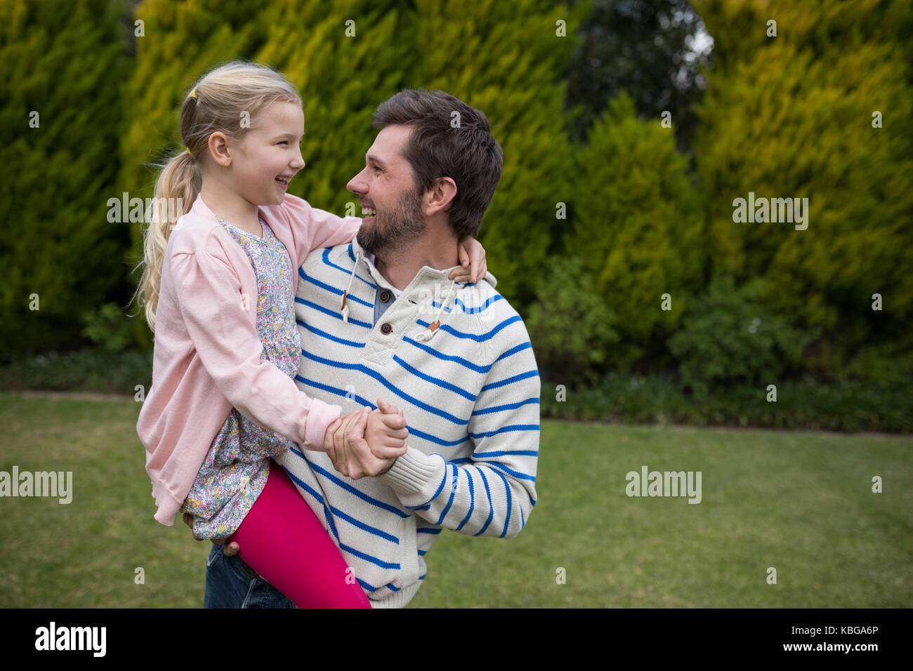 Jeune fille danse avec son père épaules dans le parc Banque D'Images