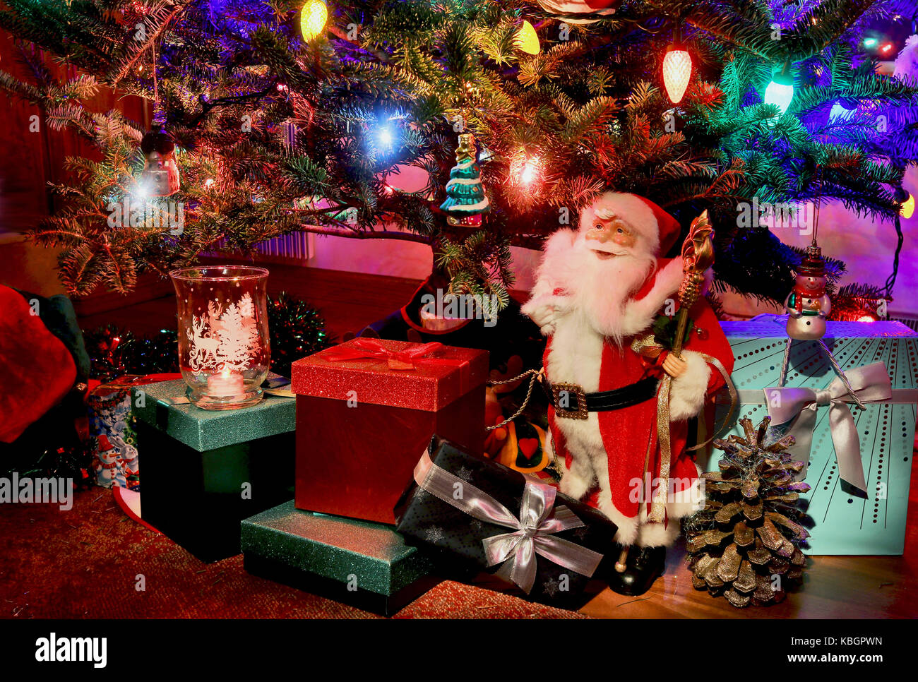 Scène de nuit avec portrait de l'arbre de Noël parfait, santa clause et coffrets cadeaux sous elle. bon pour une saison des cartes de vœux. Banque D'Images
