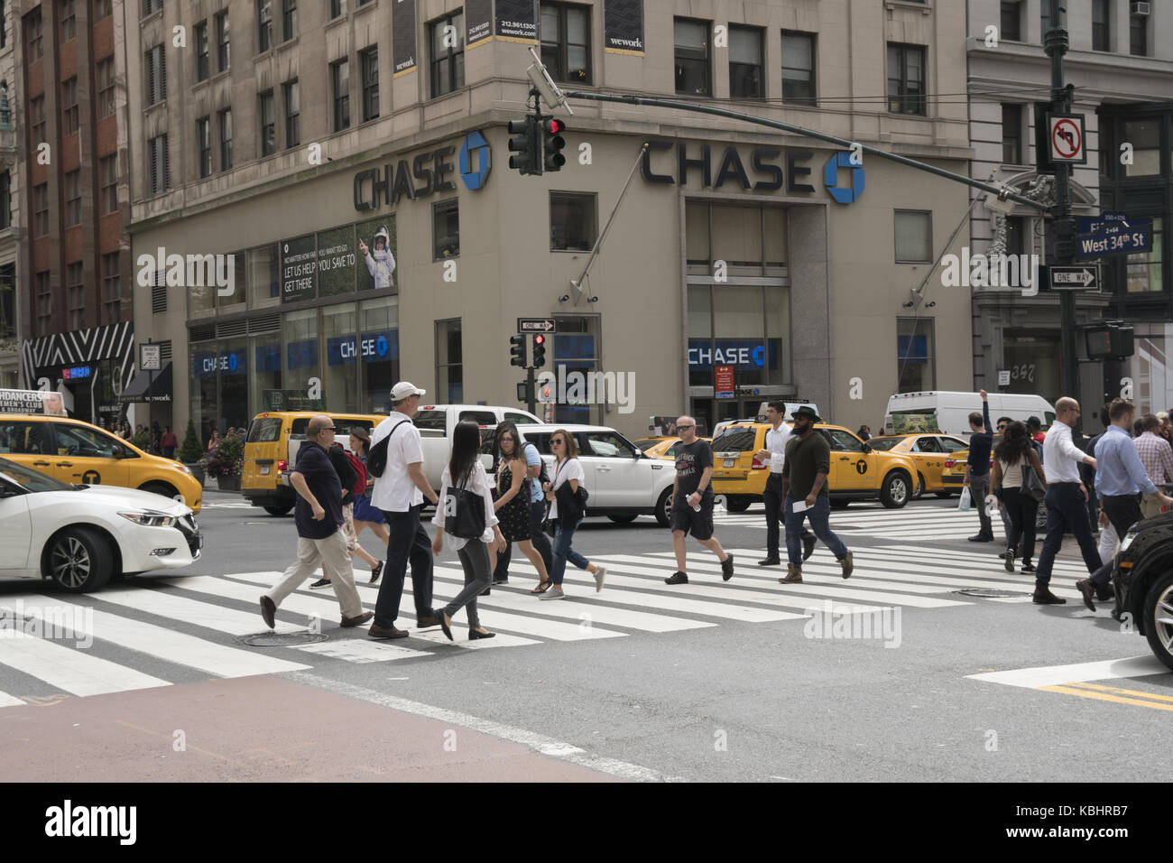 Les piétons traversent la 34e rue sur la 5e avenue, avec une omniprésence chase bank succursale dans l'arrière-plan dans le centre de Manhattan. Banque D'Images
