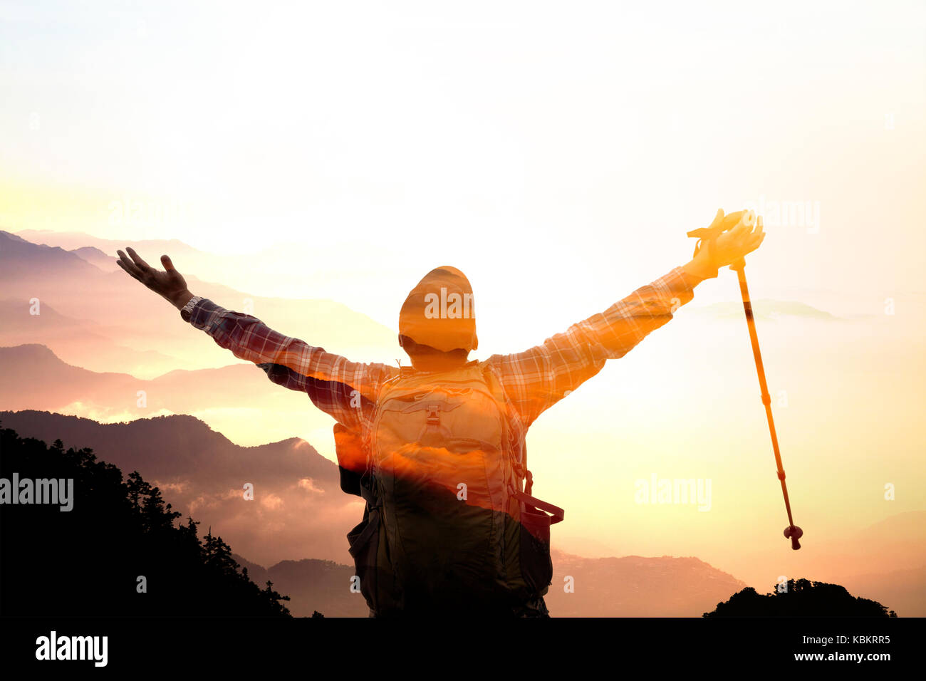 L'homme double exposition sur le sommet de la montagne en regardant le lever du soleil Banque D'Images