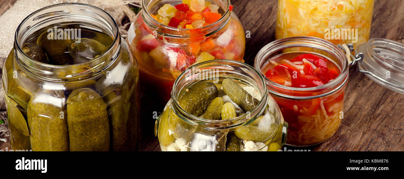 Conserves de légumes sur un arrière-plan sombre panorama rustique. Banque D'Images