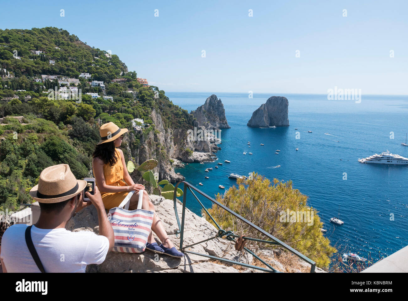 Capri vue les plus emblématiques est la dramatique Faraglioni, trois formations rocheuses imposantes qui sortent en provenance de la Méditerranée juste à côté de la côte de l'île. Banque D'Images