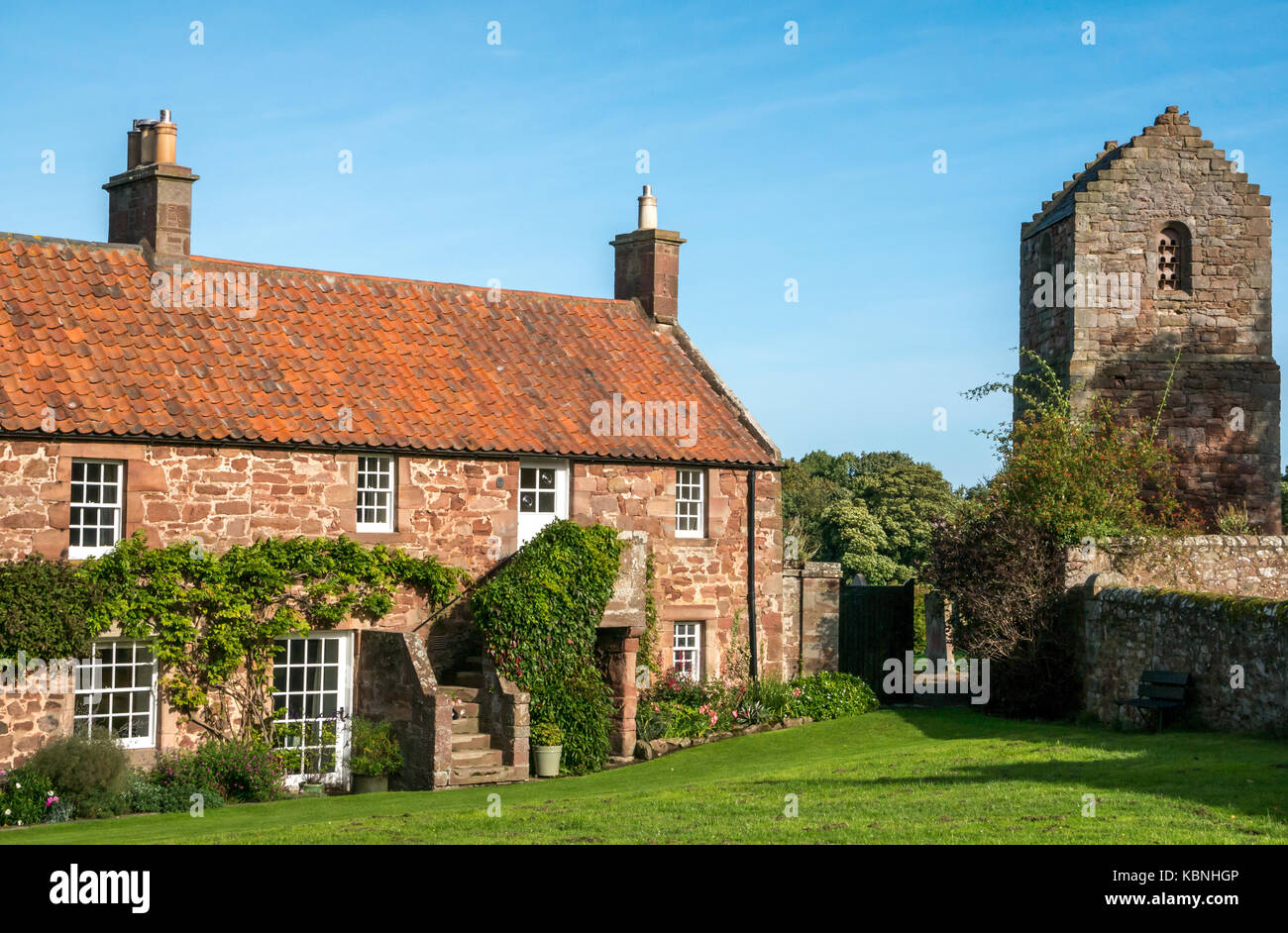 Journée ensoleillée en Stenton village green, East Lothian, Scotland, UK avec moellons rouge cottages et tour pigeonnier avec ciel bleu Banque D'Images