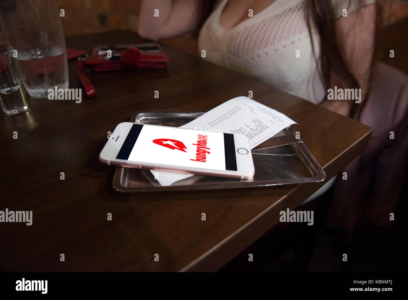 Chambre faim app sur un iphone d'Apple dans un restaurant avec le projet de loi tandis que sur une date. credit lee ramsden / alamy Banque D'Images