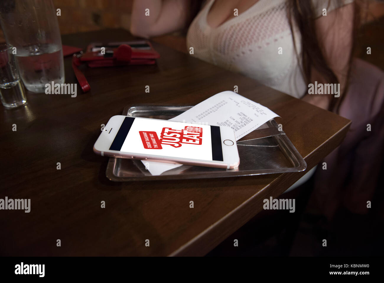 Mangez juste app sur un iphone d'Apple dans un restaurant avec le projet de loi tandis que sur une date. credit lee ramsden / alamy Banque D'Images