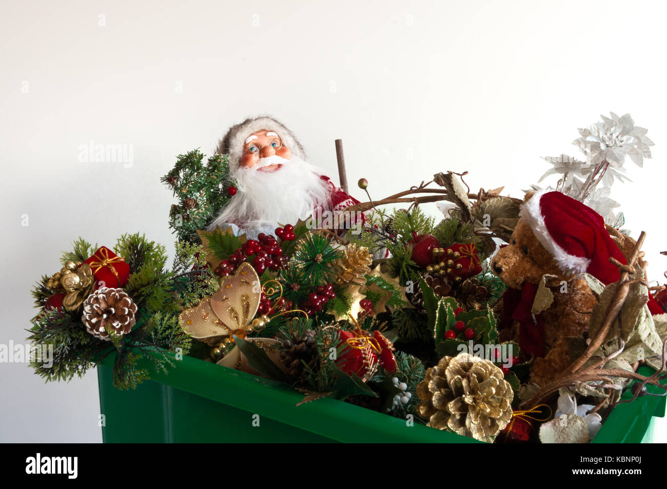 Boîte contenant les décorations de Noël dont un père noël et un ours en peluche. Banque D'Images