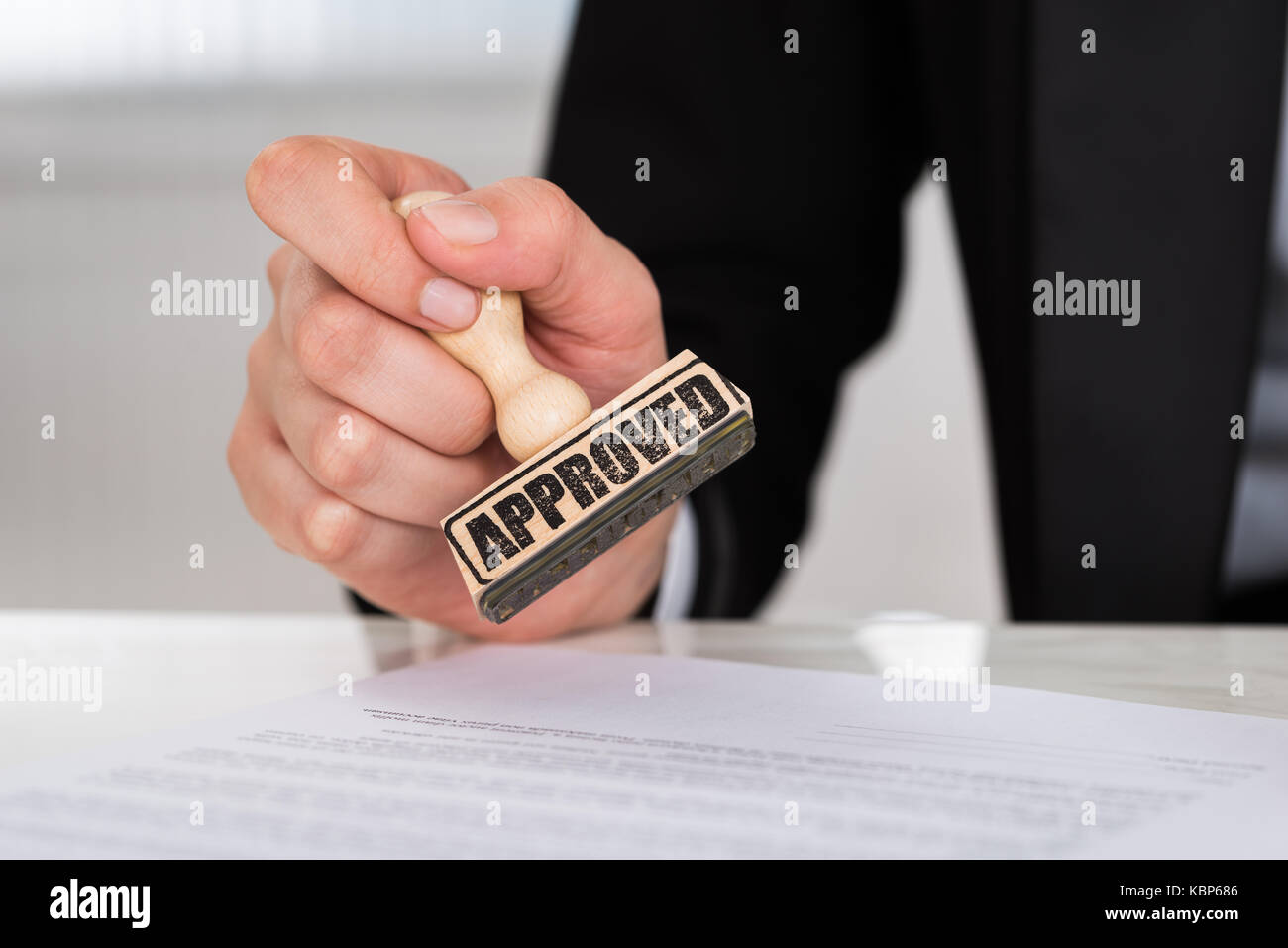Portrait of businesswoman stamping approuvé le document contrat at desk in office Banque D'Images