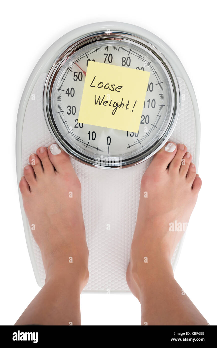 Tourné directement au-dessus de la femme debout sur l'échelle de poids à perdre du poids remarque Banque D'Images