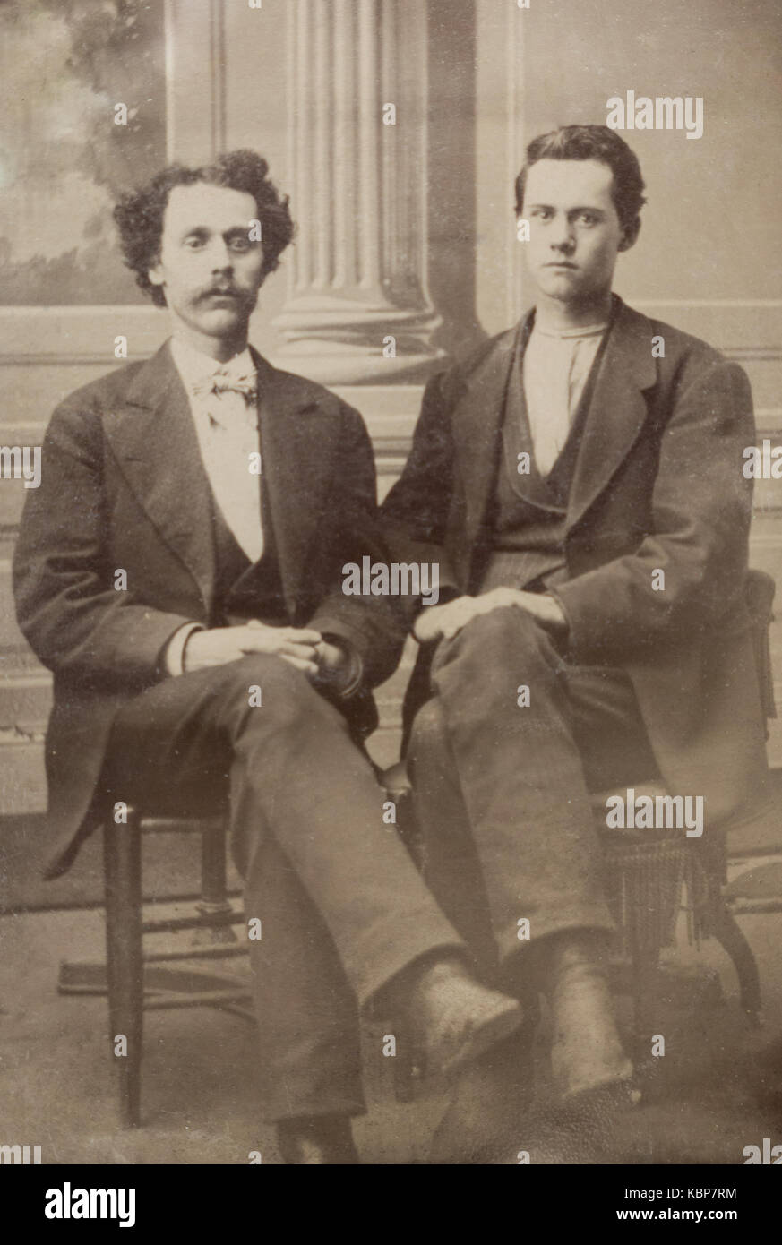 Archive américaine studio monochrome sur plaque ferrotype portrait de deux jeunes hommes assis sur des chaises, un avec une moustache, prises à la fin du 19e siècle, New York, USA Banque D'Images