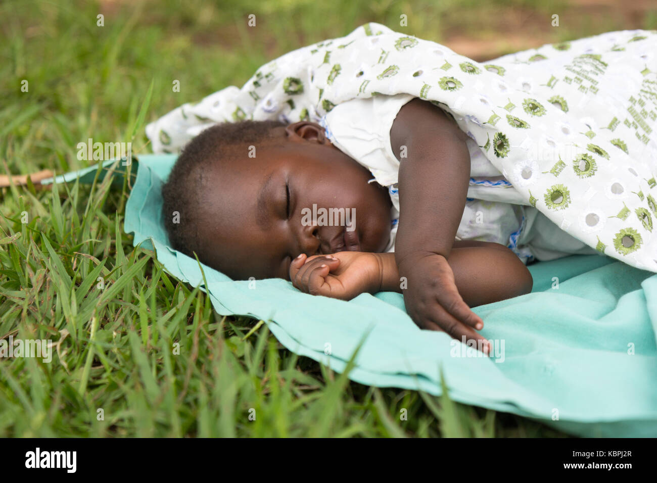 Un Joli Bebe Noir Dormant Sur Une Couverture Dans L Herbe Photo Stock Alamy