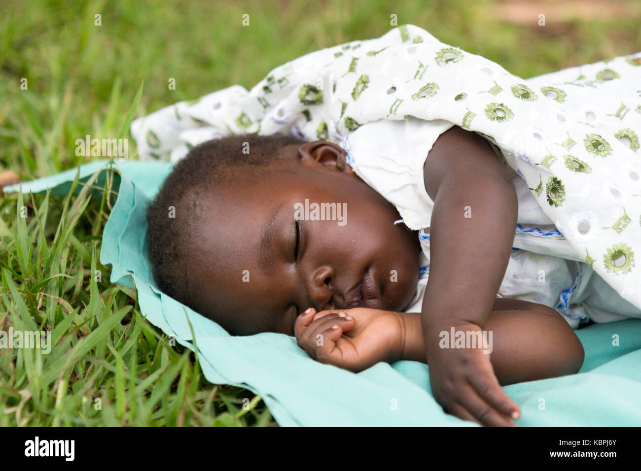 Un Joli Bebe Noir Dormant Sur Une Couverture Dans L Herbe Photo Stock Alamy