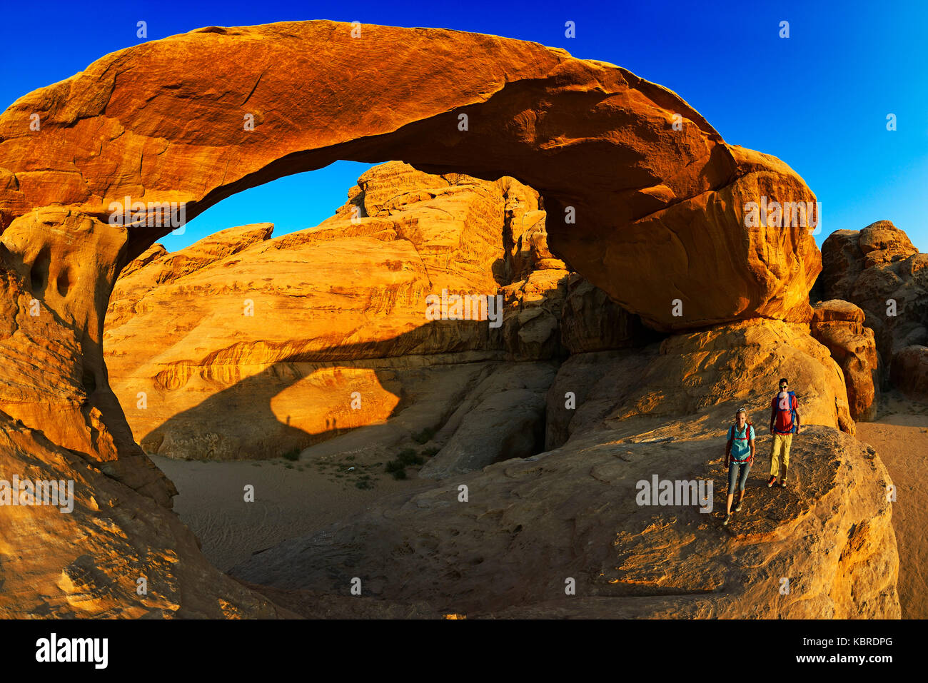 Couple hiking à Rock-Arch Al Kharza, Wadi Rum, Jordanie Banque D'Images