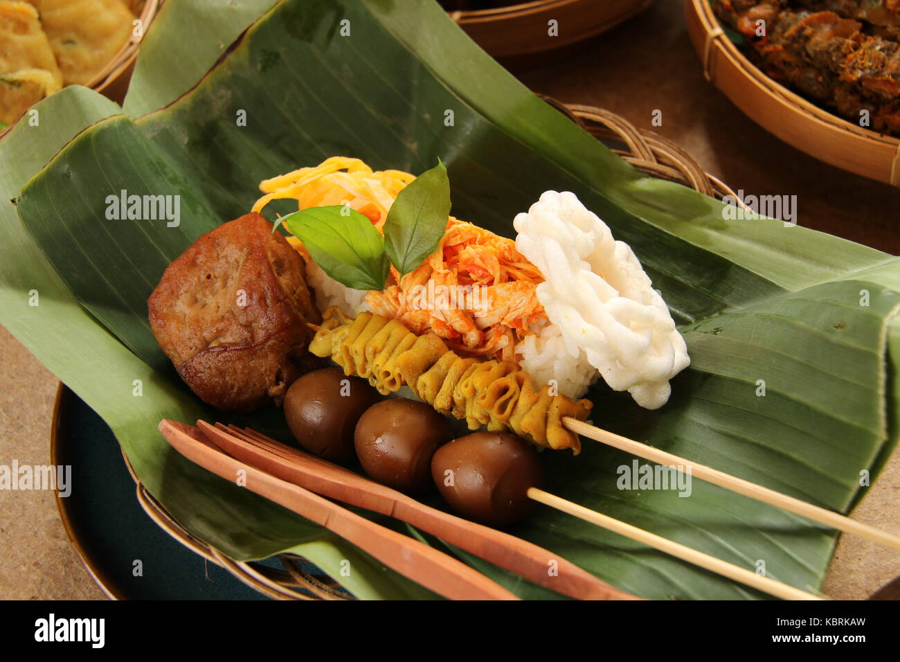 Nasi ayam kucing javanais. suwir petite partie plat de riz avec poulet épicé topping et accompagnements de satays, beancurd, et de craquelins. Banque D'Images