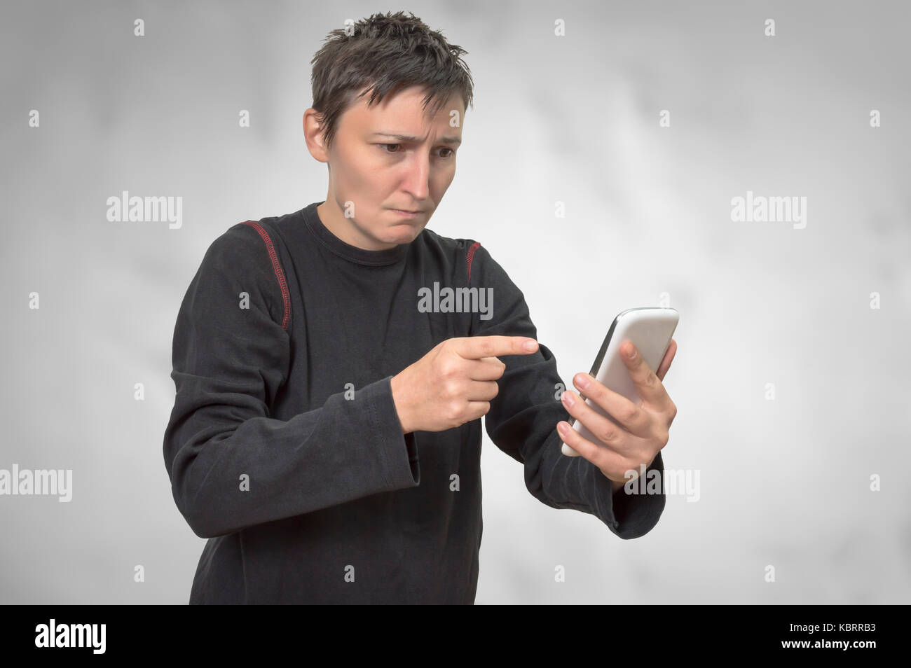 Femme en colère en criant pour téléphone mobile, isolé sur fond lumineux. Banque D'Images