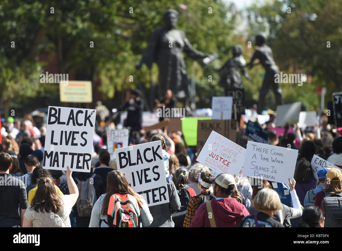 Washington, DC, USA. Sep 30, 2017. Transporter les marcheurs de leurs signes dans Lincoln Park avec le Mary McLeod Bethune Memorial à l'arrière-plan pendant la marche pour la justice raciale de Lincoln Park de la capitale à Washington, DC. Credit : csm/Alamy Live News Banque D'Images