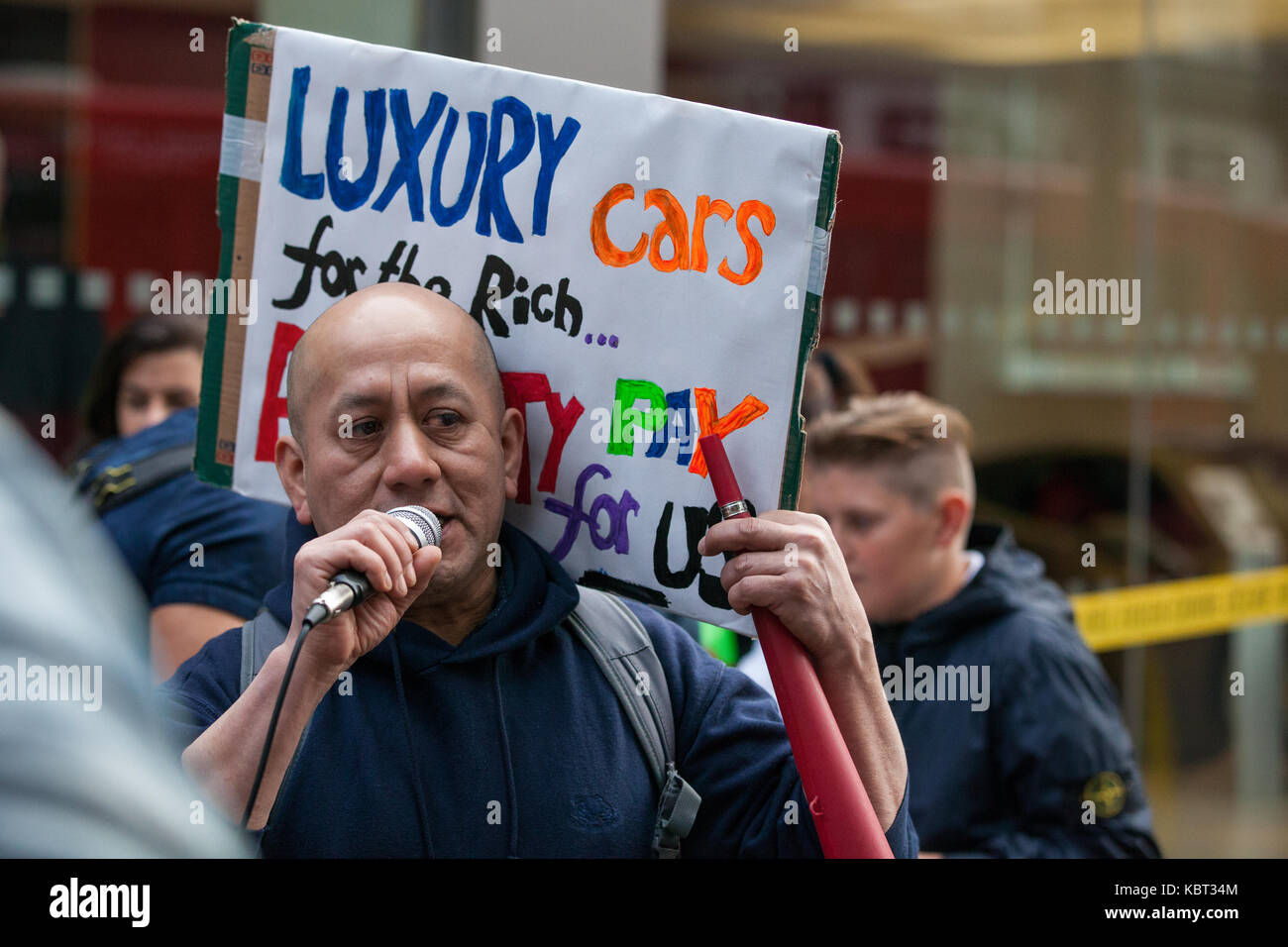 Londres, Royaume-Uni. 30 septembre, 2017. cleaner fredy lopez, suspendu sans solde avec son partenaire angelica valencia bolanos templewood pour nettoyage par l'entrepreneur ayant rejoint l'Union européenne commerce united musique du monde et pour avoir voté pour la grève pour le london living wage, adresses manifestants à l'extérieur de la voiture de luxe h.r. Owen's showroom ferrari dans South Kensington. les femmes de ménage, un couple marié, sont les seuls responsables pour le nettoyage nettoyeurs h.r. Owen's Ferrari et Maserati via alpina templewood entrepreneur nettoyage. crédit : mark kerrison/Alamy live news Banque D'Images