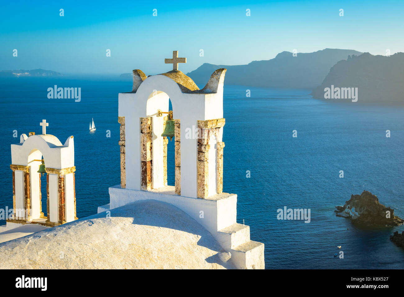 Les cloches de l'église sur une église orthodoxe grecque donnant sur la mer Égée, dans la ville de Oia sur l'île de Santorin dans les Cyclades au large de la côte de main Banque D'Images