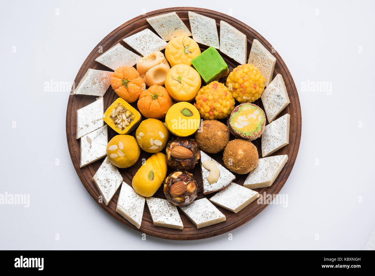 Stock photo de sucreries indiennes servi dans l'argent ou plaque de bois. variété de peda, burfi, laddu en plaque décorative, selective focus Banque D'Images