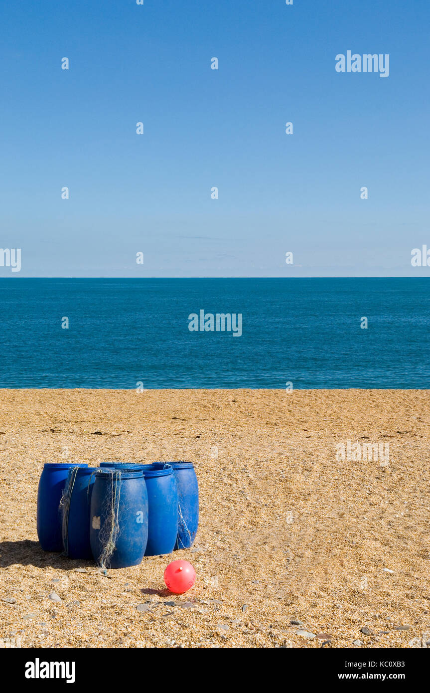 Groupe des barils en plastique bleu sur la plage de sable, lieu non identifié, torcross devon avec la mer et un horizon bleu clair à l'arrière-plan. Fruits de mer coast Banque D'Images