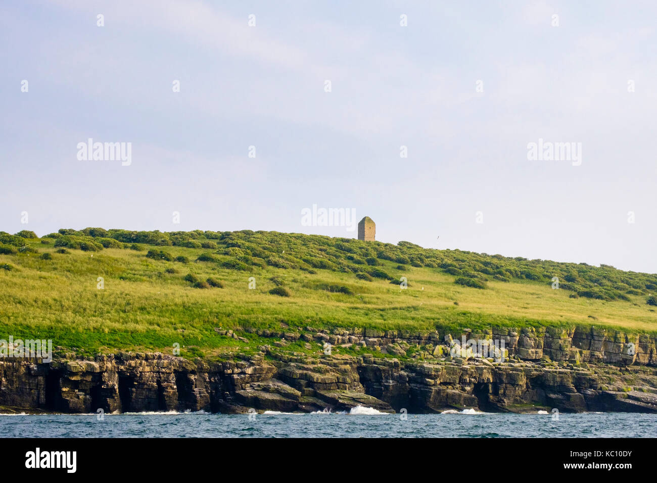 L'île de macareux ou Priestholm église du 12ème siècle dédiée à Saint Seiriol avec les colonies de nidification des oiseaux de mer sur les barres rocheuses. Anglesey Pays de Galles UK Banque D'Images