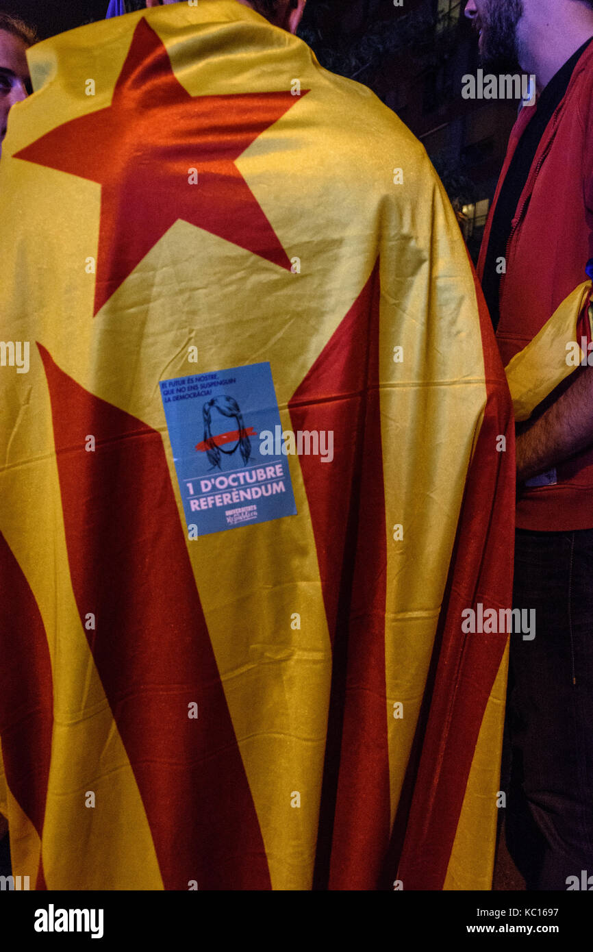 Un manifestant porte un drapeau sur son dos lors d'un rassemblement DE TASSE à Poble Nou. Banque D'Images