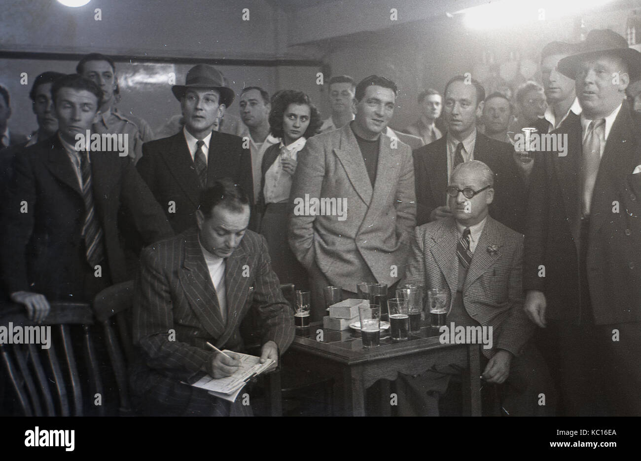 Années 1950, historique, groupe de personnes, essentiellement des hommes, les journalistes pour un journal local, de prendre un verre tout en regardant un match de fléchettes travaille, Angleterre, Royaume-Uni. Banque D'Images