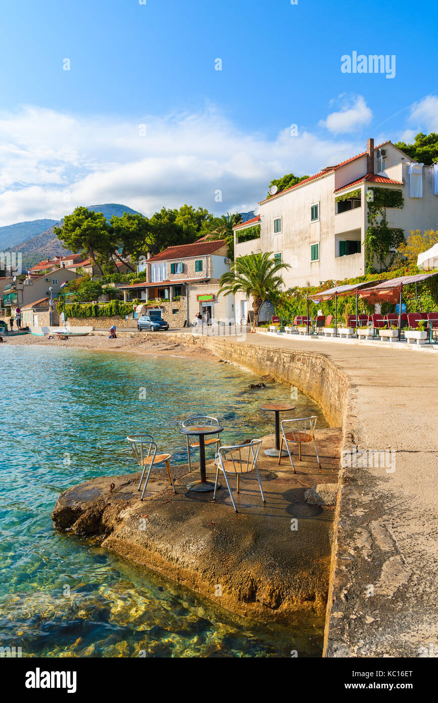 La ville de Bol, Croatie - SEP 8, 2017 : Des chaises avec tables de bar côtières sur les rochers et vue sur la côte dans la ville de Bol, Île de Brac, Croatie. Banque D'Images