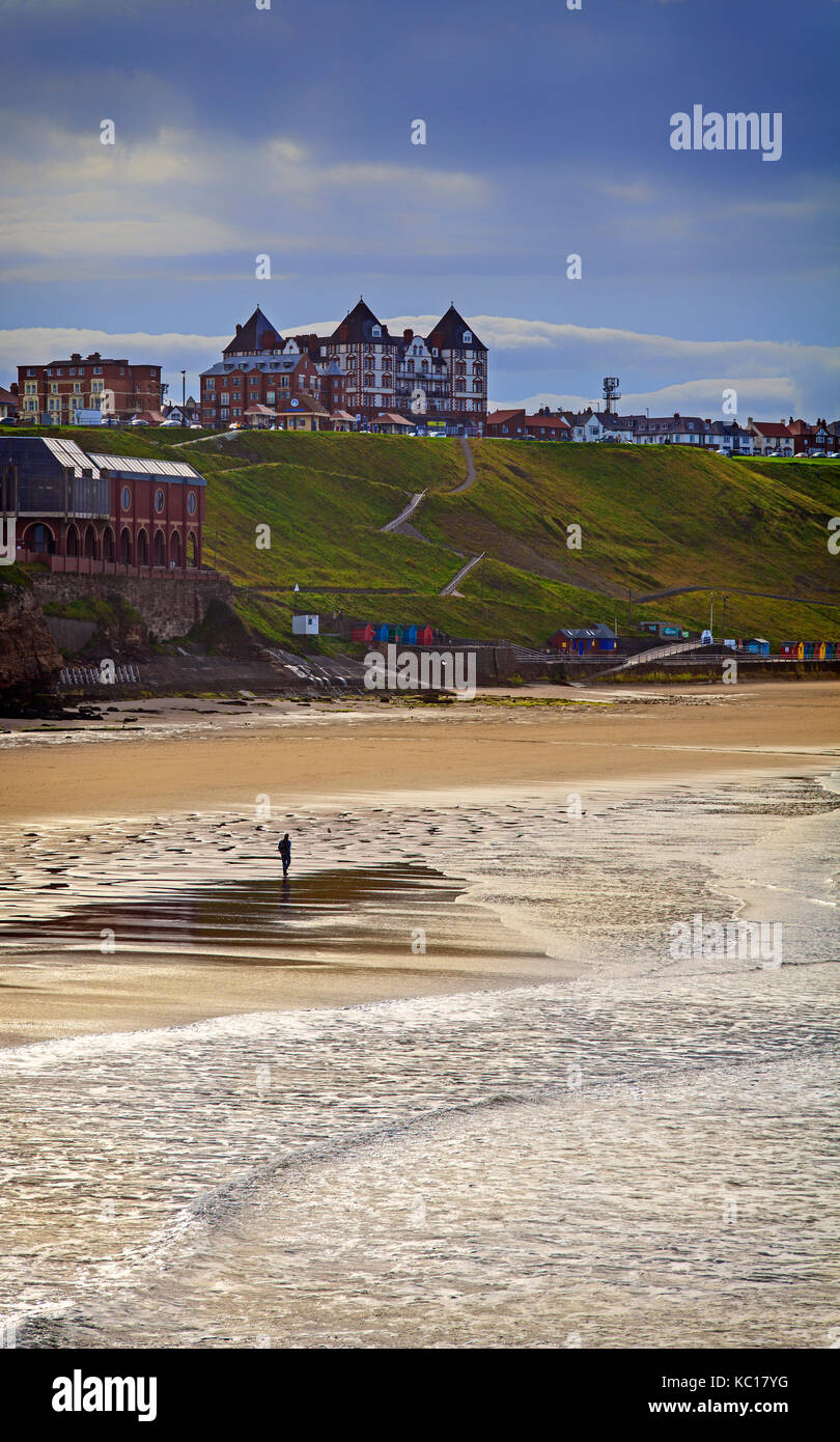 Promeneur solitaire sur la plage du nord dominé par la metropole Luxury apartments sur la zone de West Cliff de Whitby, Yorkshire, Angleterre Banque D'Images