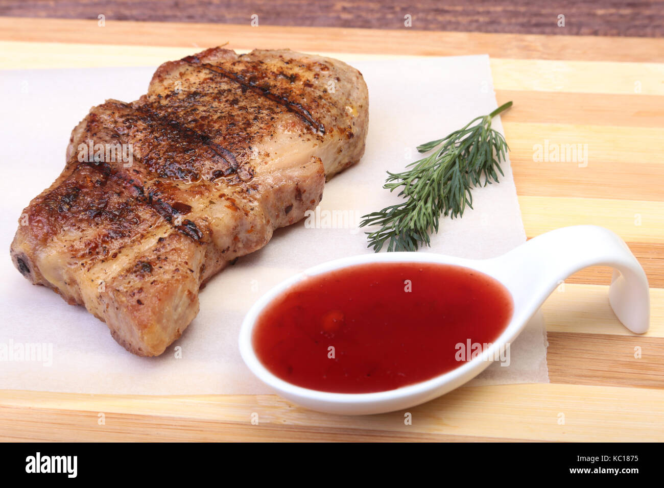 Côtelette de porc grillé avec sauce aux canneberges sur la plaque sur