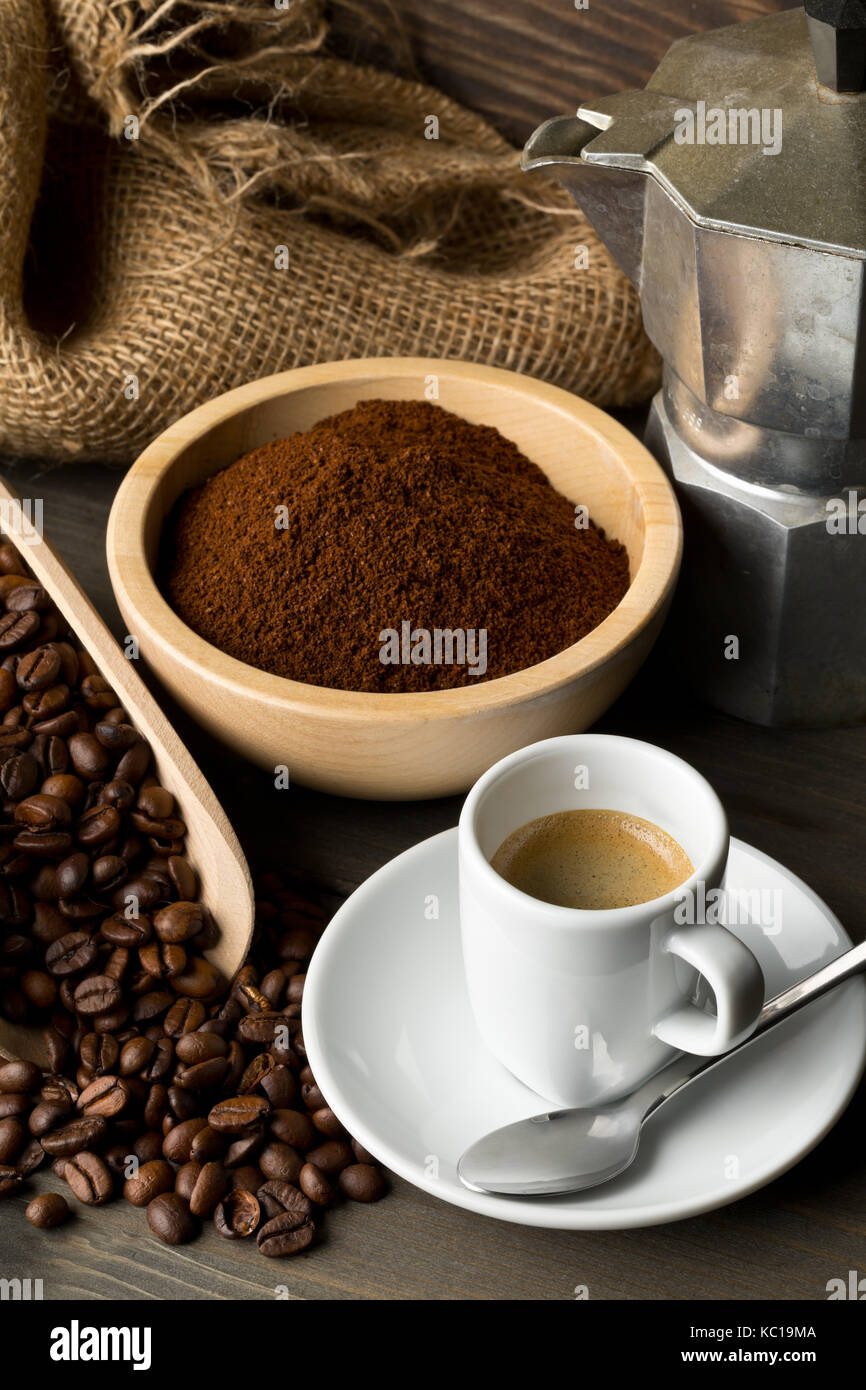 Les grains de café, café moulu en poudre et tasse de café espresso avec  plaque de cuisson cafetière sur fond de table en bois foncé Photo Stock -  Alamy