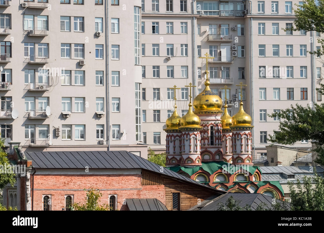 Les dômes dorés et les coupoles de l'église de Saint Nikolas sur Bersenevka Street, entouré de grands immeubles urbains modernes, Moscou, Russie. Banque D'Images