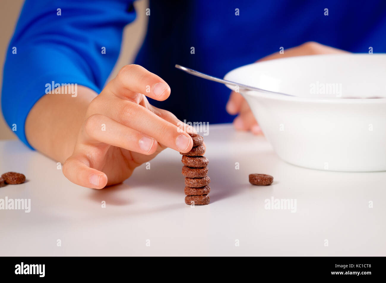 Close up of hands de kid de manger des céréales pour le petit déjeuner ou le déjeuner. Banque D'Images