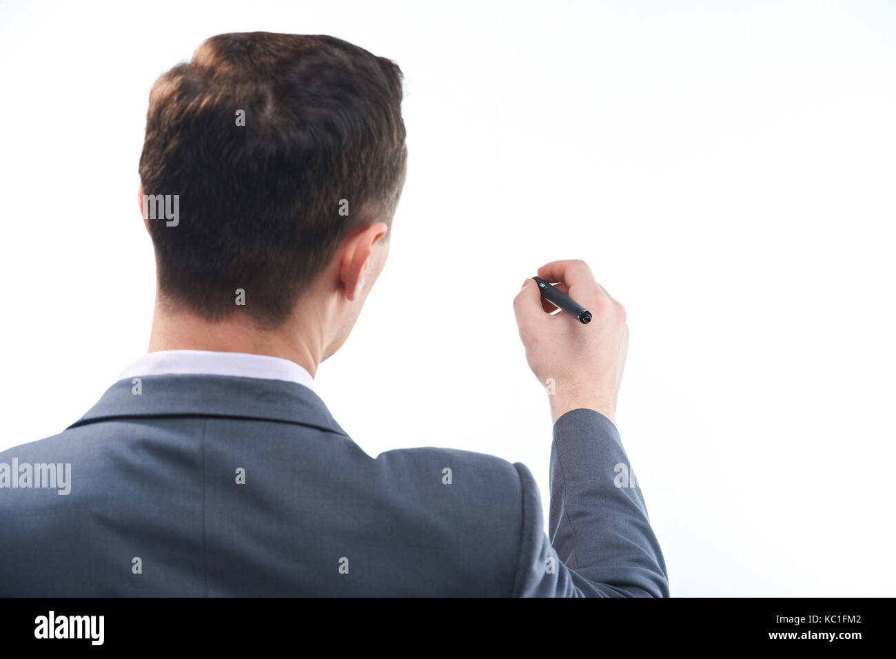 L'homme d'affaires part tenir un stylo et écrit sur un tableau blanc isolé Banque D'Images L'homme d'affaires part tenir un stylo et écrit sur un tableau blanc isolé Banque D'Images