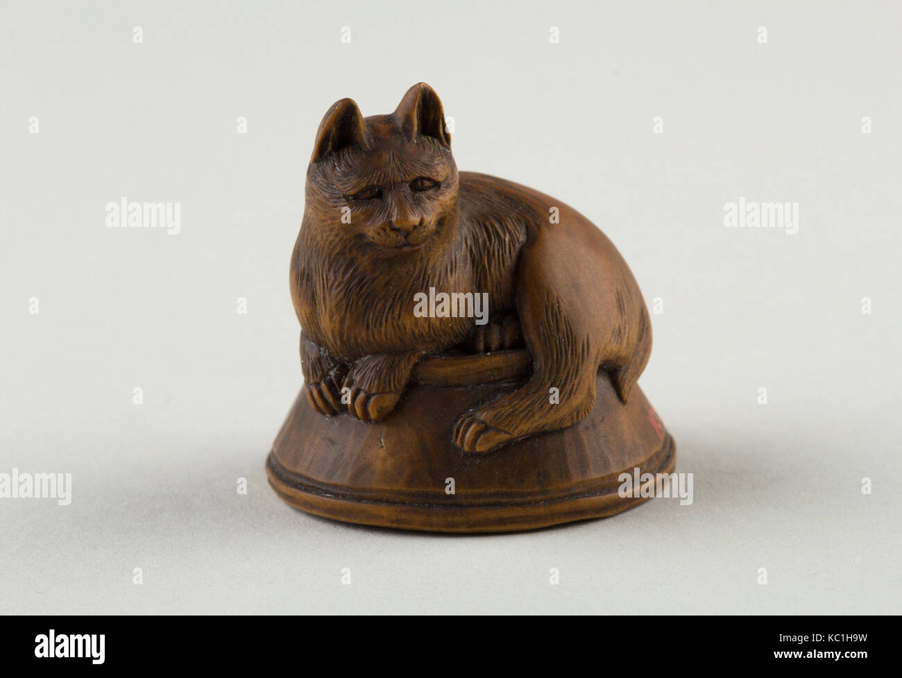 Netsuke de Cat allongé sur un bol, sous lequel est un poisson, 19e siècle Banque D'Images