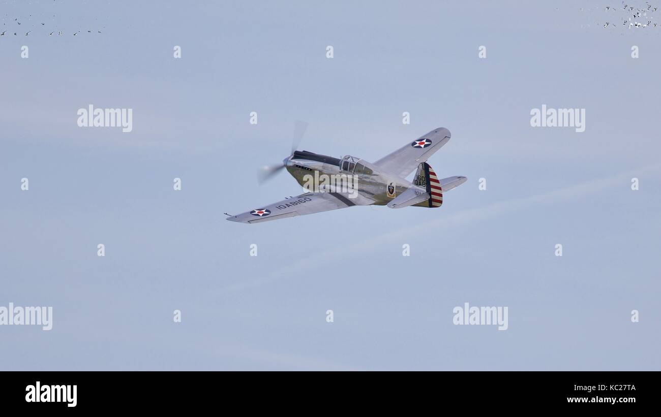 Un bel exemple de Curtiss-Wright Warhawk P-40C volant à la bataille d'Angleterre 2017 Air Show à l'IWM Duxford Banque D'Images