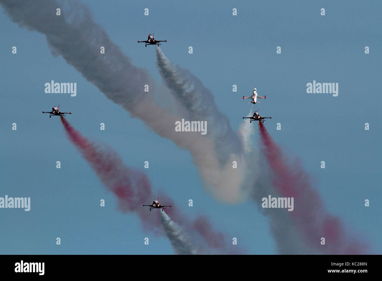 Affichage par l'équipe de voltige Stars turques de l'air turque. Un avion vole sur la tête grâce à un ralentissement de la formation de vol de quatre. Banque D'Images