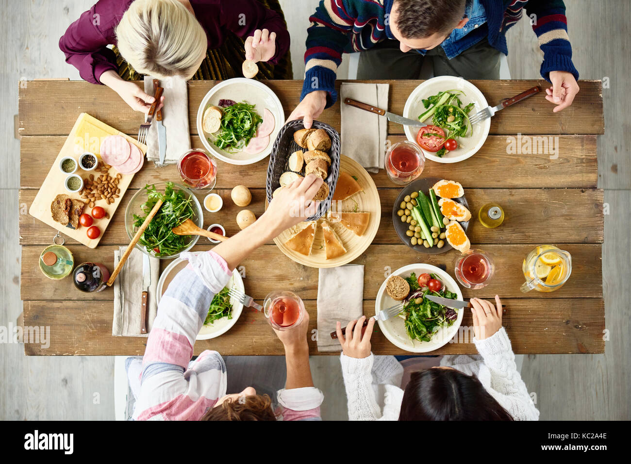 Voir ci-dessus de quatre personnes manger de délicieux aliments à dîner de fête à la table cafe Banque D'Images