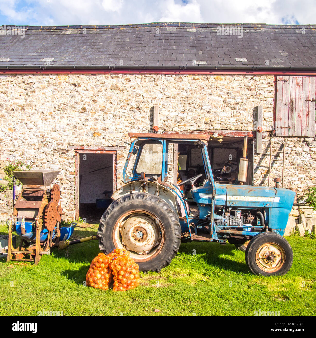 Tracteur, pommes et moulin à pomme à Goren Farm, une ferme biologique à Devon, en Angleterre Banque D'Images